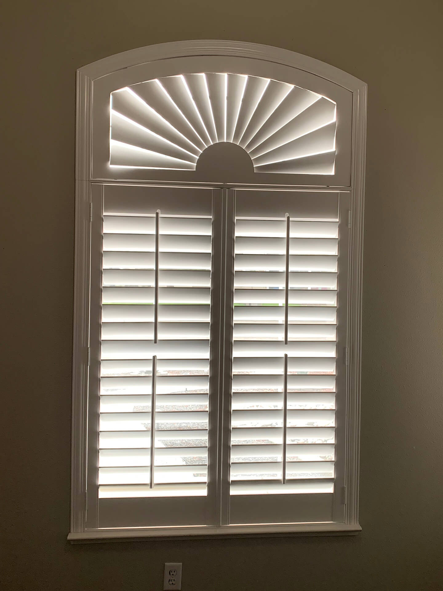 A single window covered with decorative shutters.