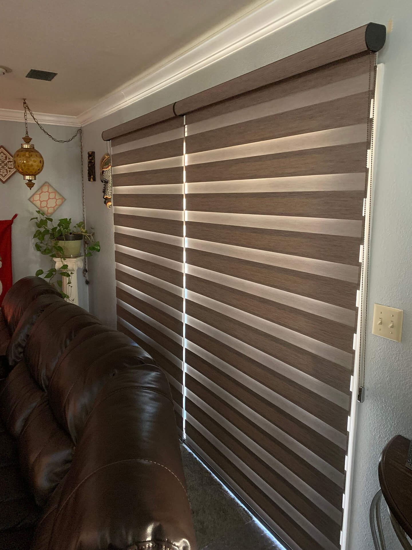 Closed dual shades covering a large window behind a couch.